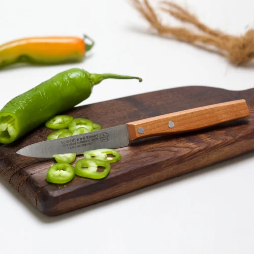 Couteau sans aiguisage avec 4 dents par mm de la gamme expert affidenté sur une planche en bois qui a coupé des piments