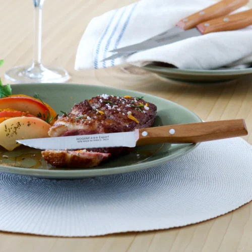 couteau steak bois dans une assiette découpant un magret de canard